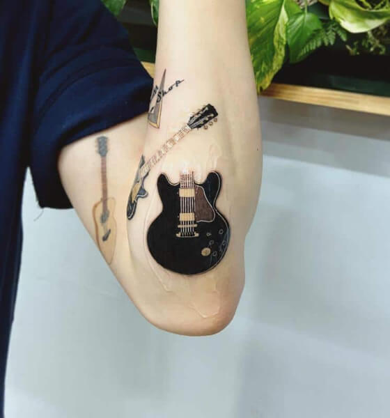 tatuaje de guitarra en el brazo izquierdo